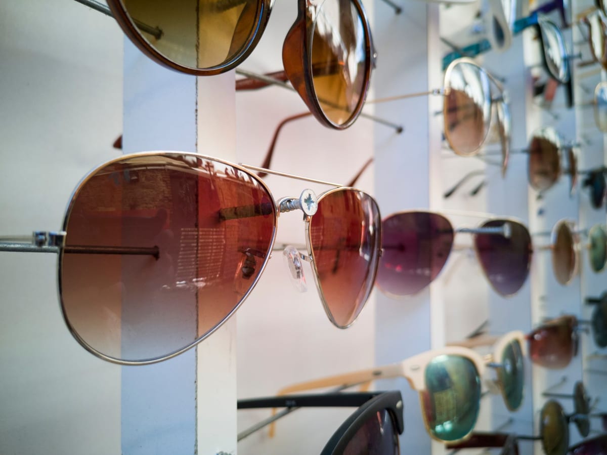 Sunglasses in assorted tints and metal frames arranged along a display rack